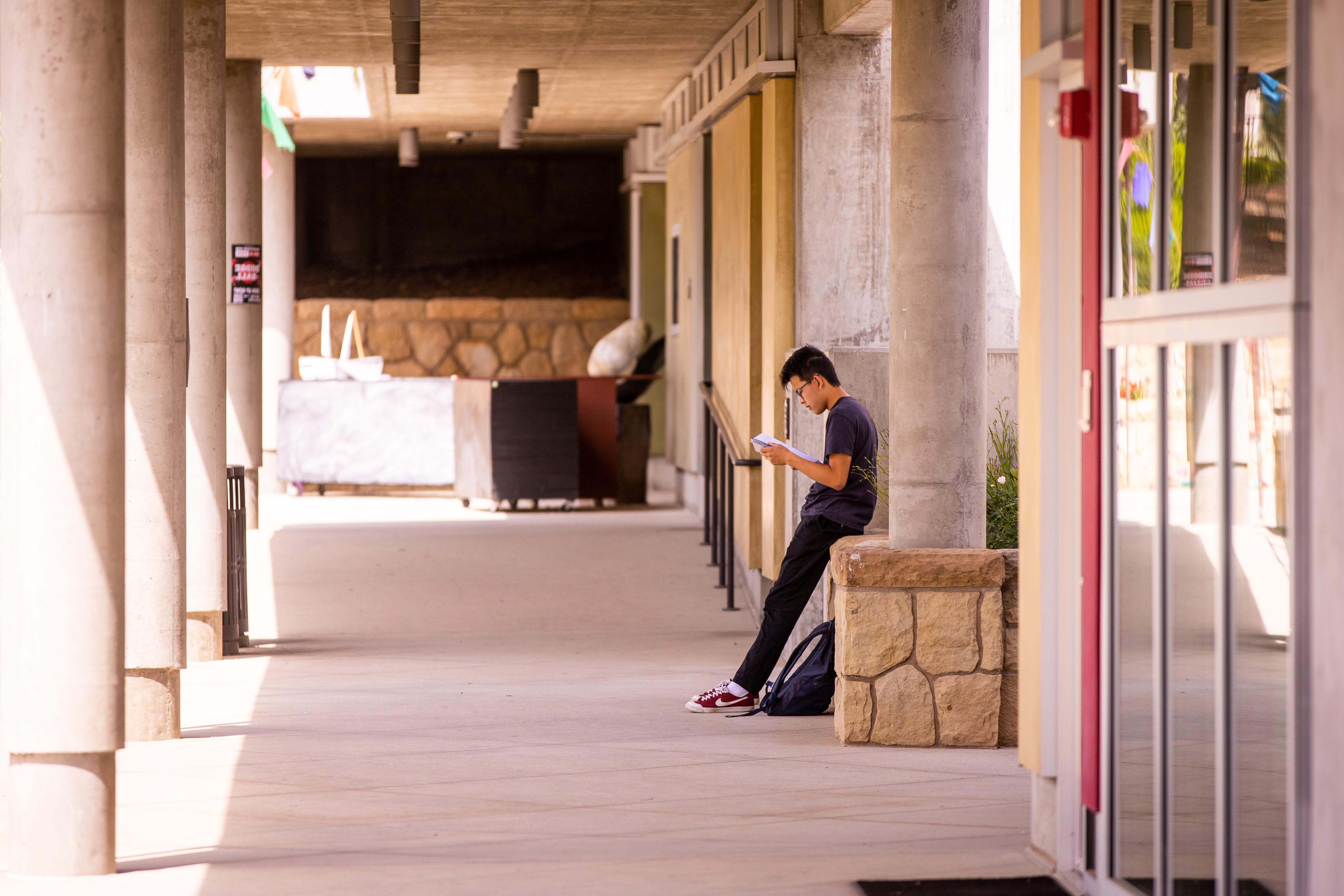 student reading in hallway